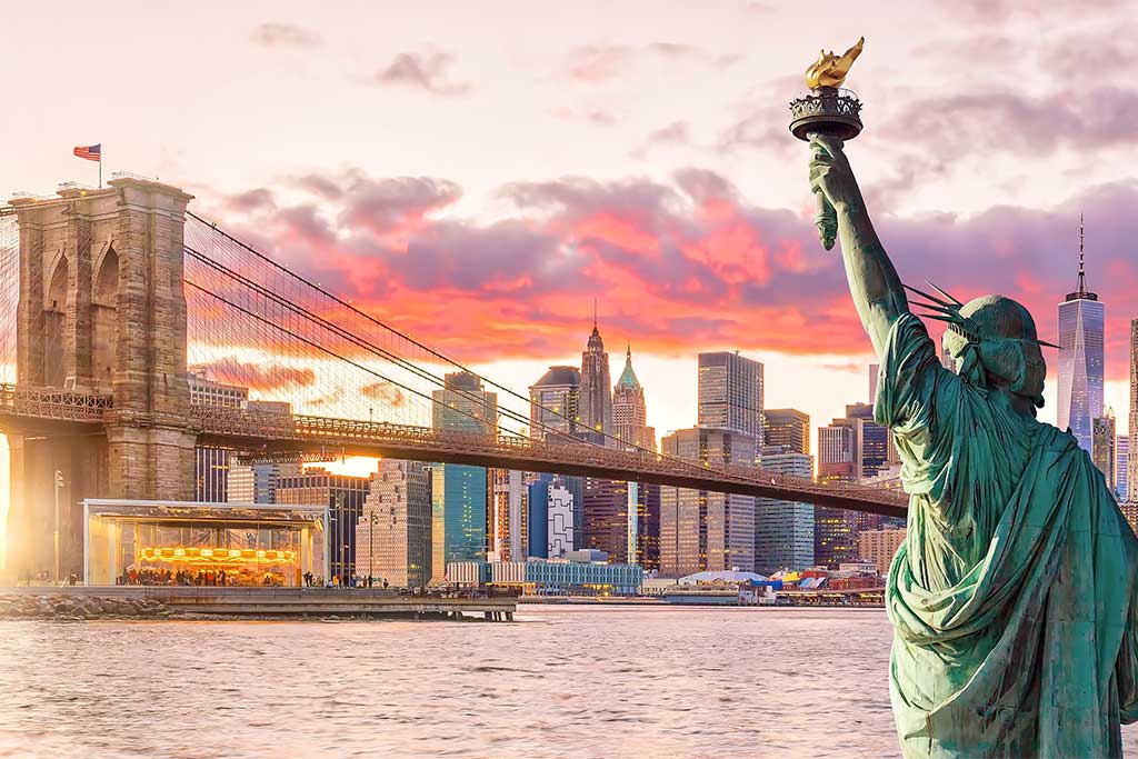 Statue Liberty and New York city skyline at sunset