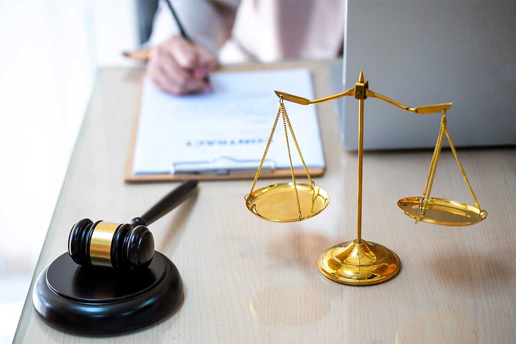 Lawyer writing documents in office with gavel, symbol of justice