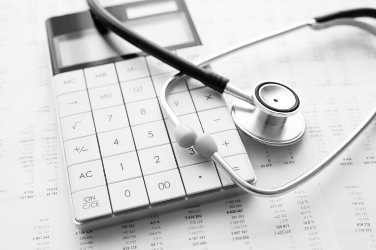 Healthcare financial analysis with calculator, stethoscope, and medical billing statements showing surgical practice revenue