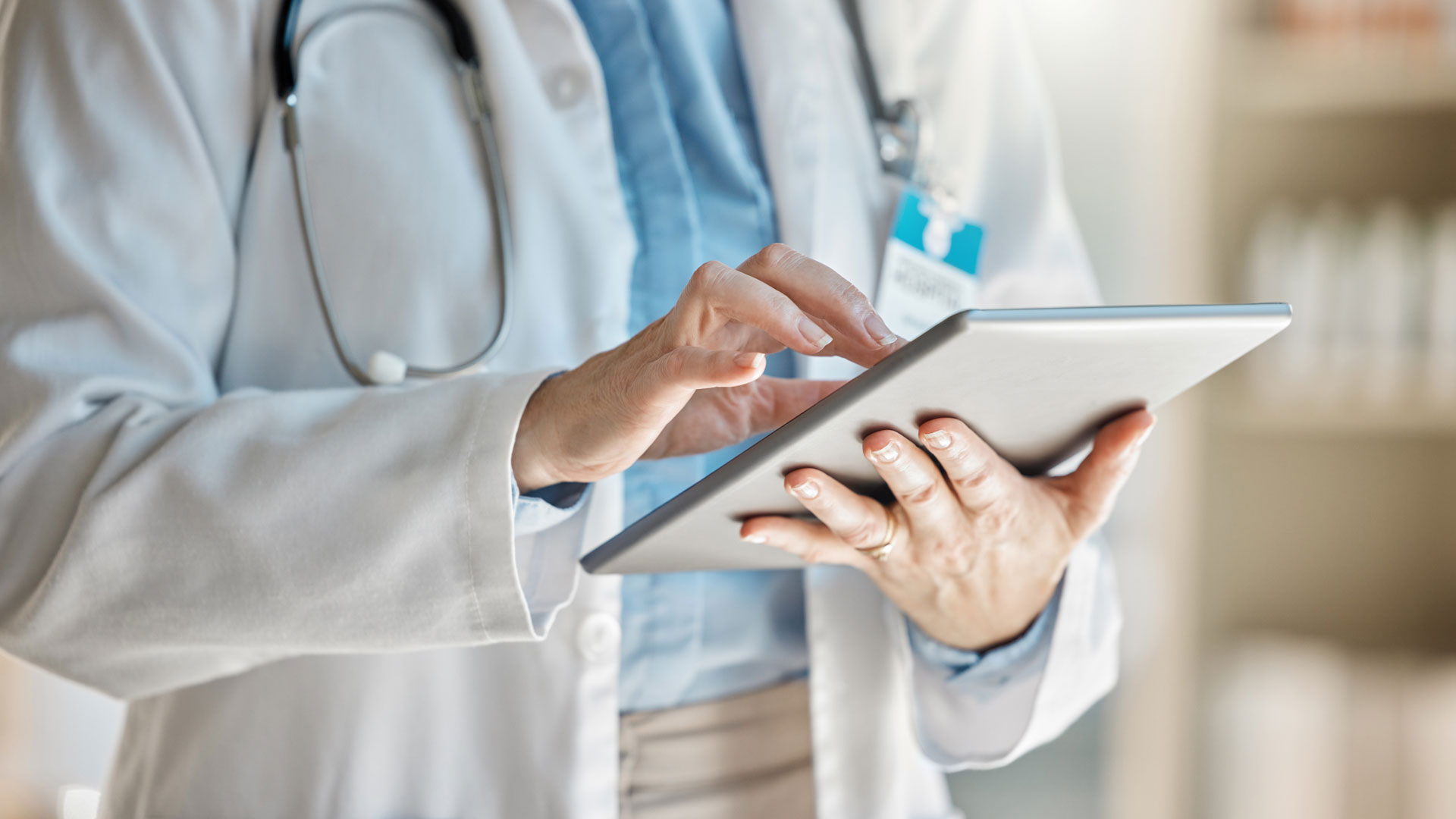 Out-of-network medical provider reviewing insurance claim on tablet.